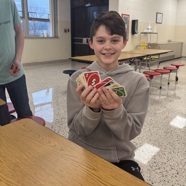 A student displays his UNO cards in a cafeteria.
