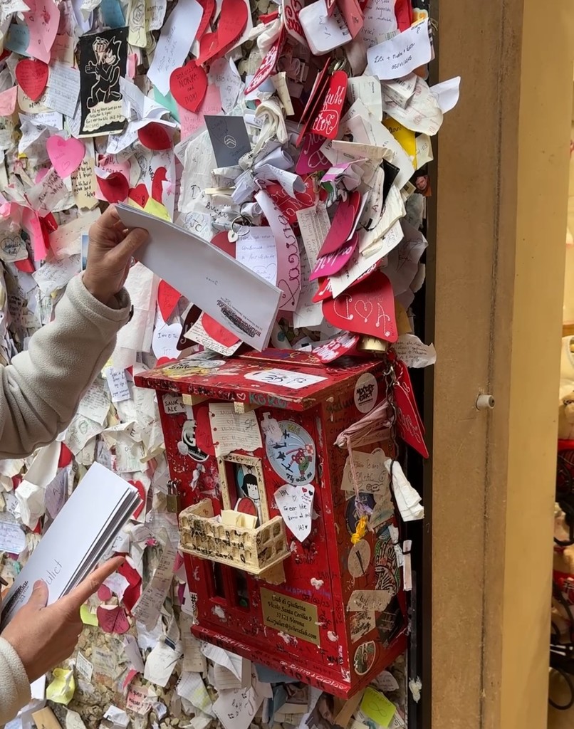 A person puts letters to Juliet into a mailbox.
