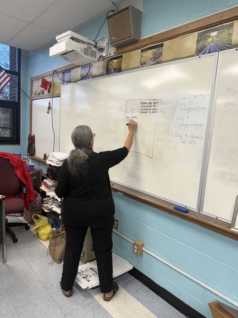 A teacher demonstrates friendly letter format on a whiteboard.