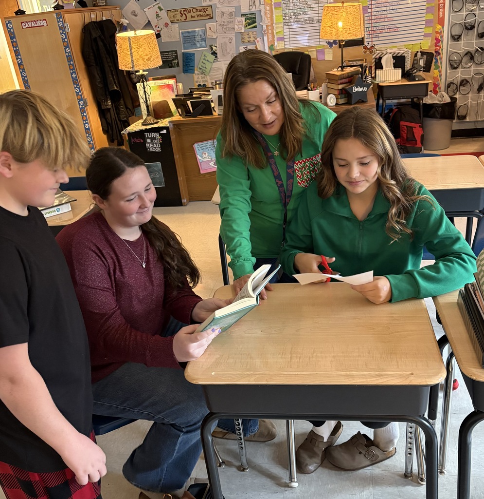 A teacher works with three students in a classroom.