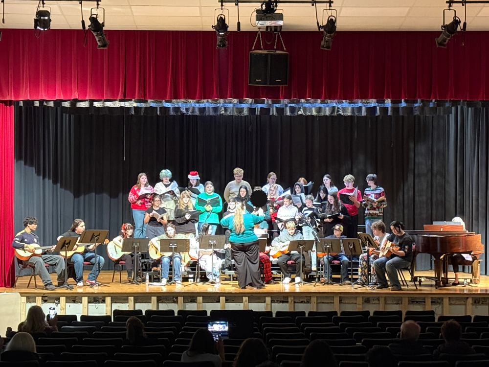 Students perform on a stage.