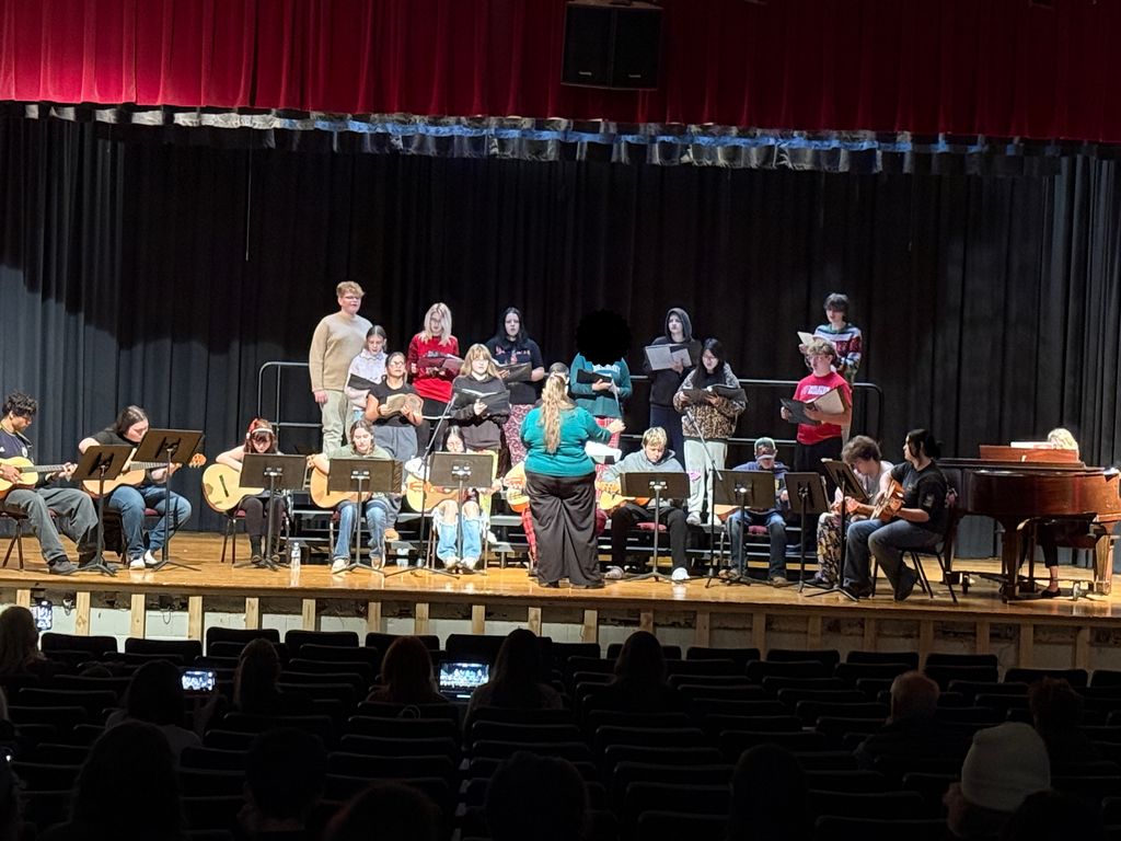 Students perform on a stage.