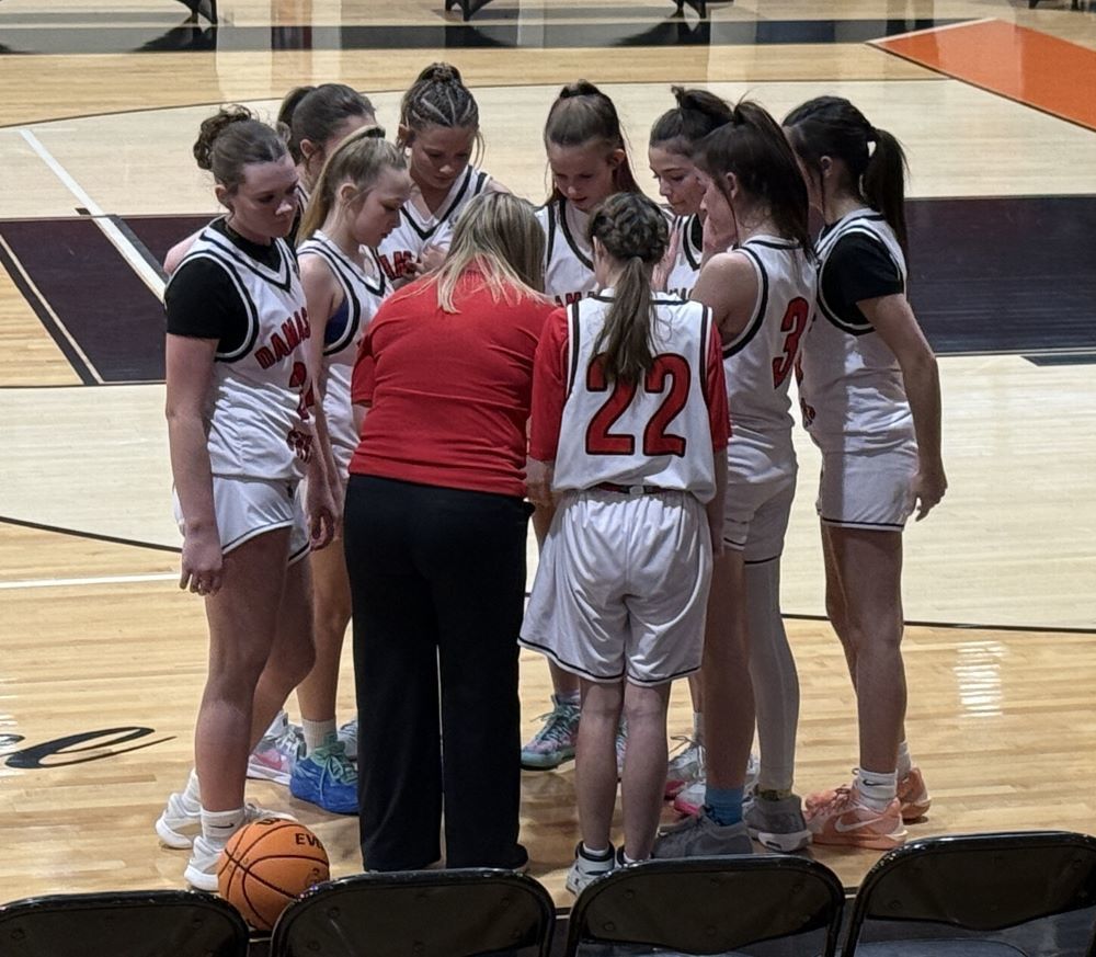 A coach talks to her basketball players.