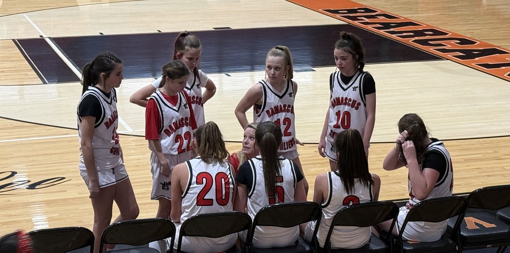 A coach talks to her basketball team.