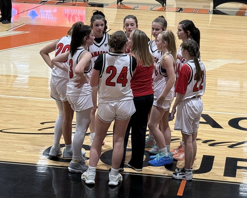 A coach talks to her basketball team.