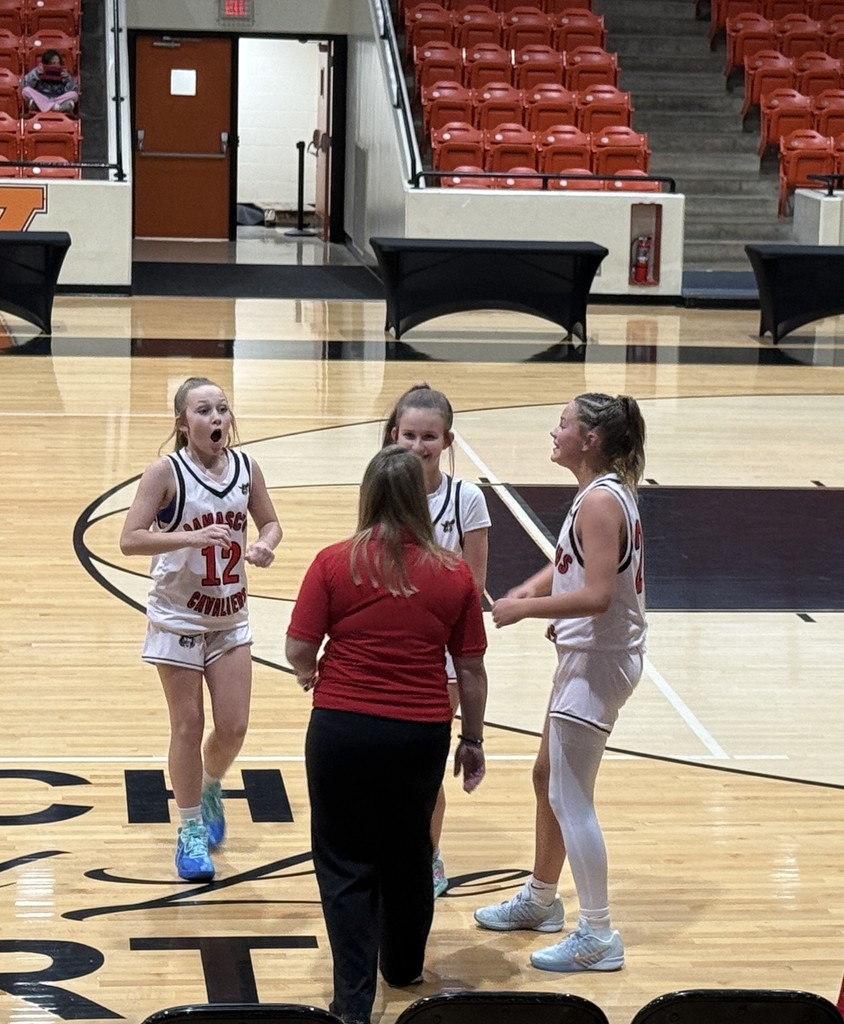 A coach talks to her basketball players.