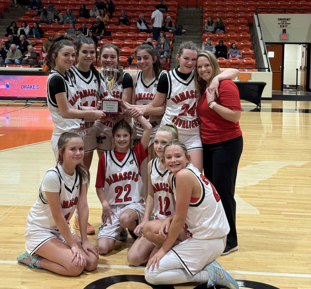 Basketball players pose with their coach and a trophy.