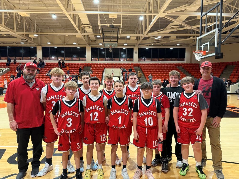 A boys basketball team poses with the coaches.