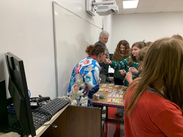Students look at fishing bait in a classroom.