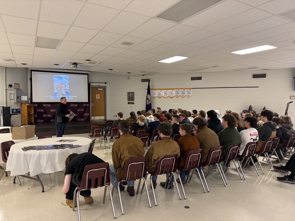 A man speaks to a group of students in an auditorium.