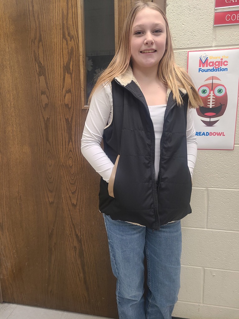 A student poses in front of a ReadBowl poster.