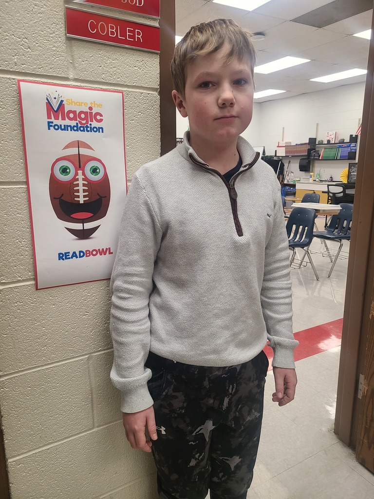 A student poses in front of a ReadBowl poster.