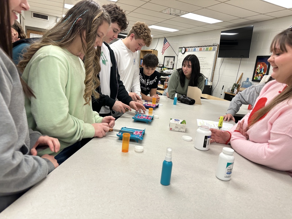 Students practice counting pills in a Pharmacy shop.