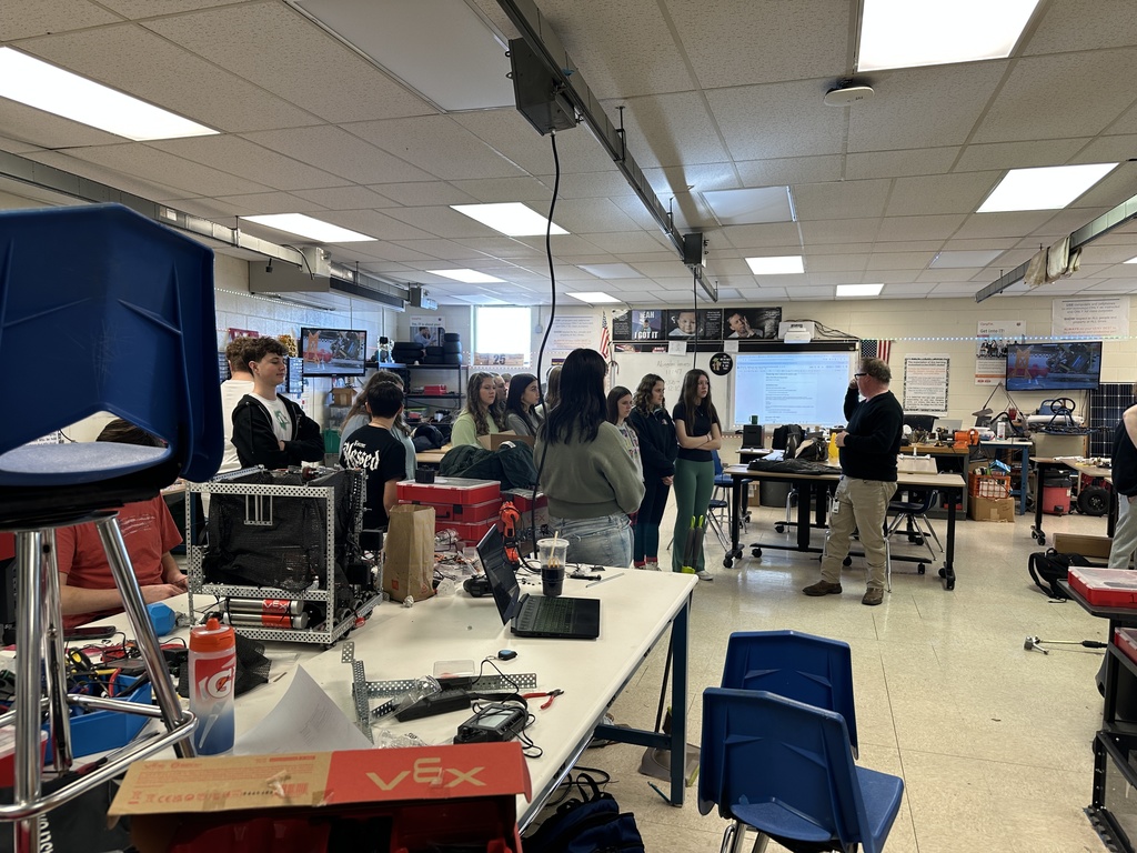 A teacher talks to students in a Robotics classroom.