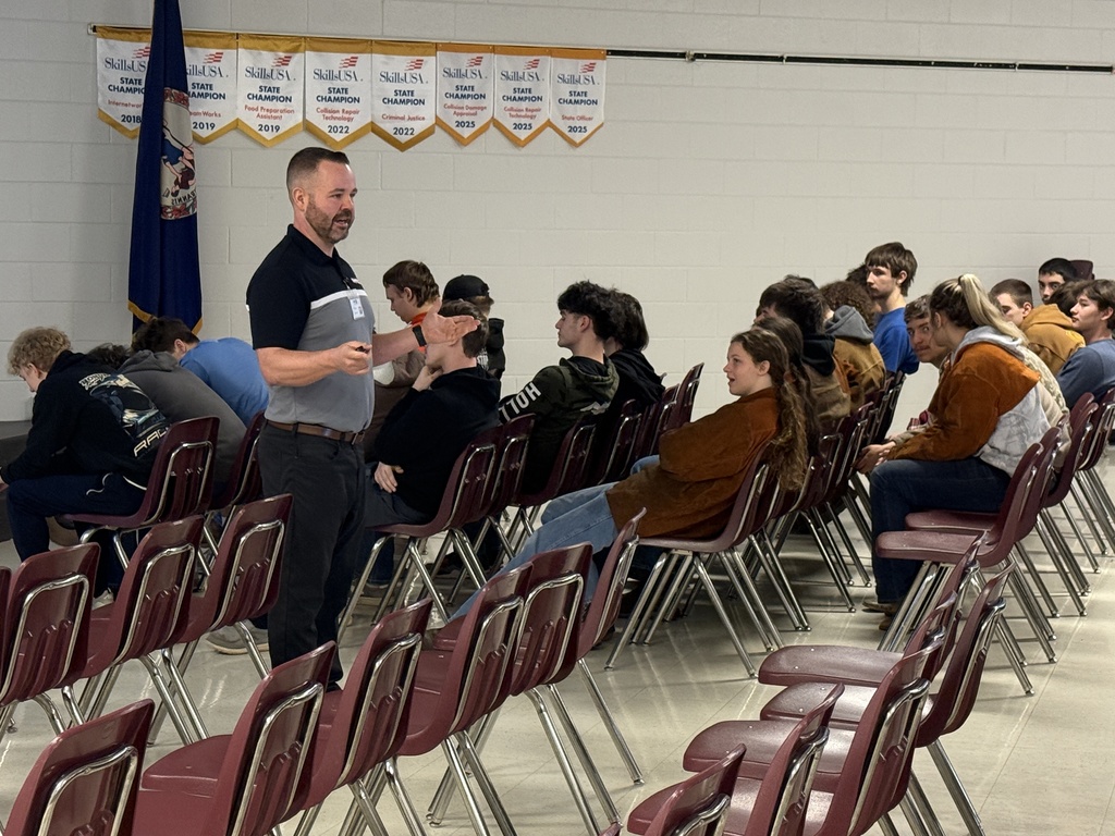 A man talks with students in an auditorium.