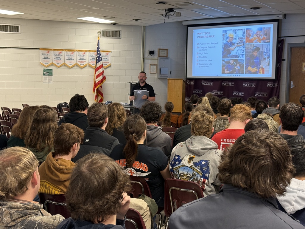 A man talks with students in an auditorium.