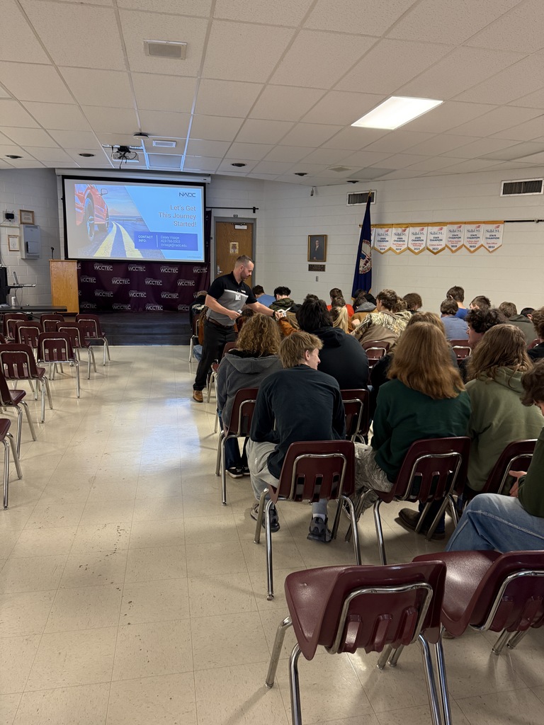 A man talks with students in an auditorium.
