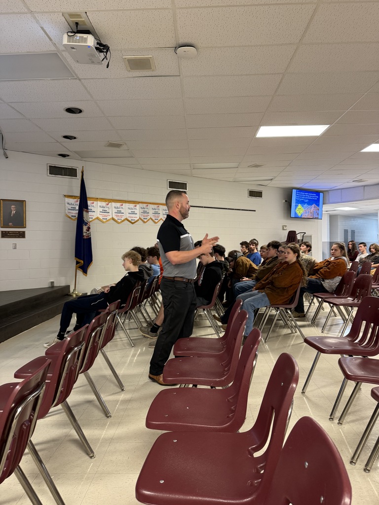 A man talks with students in an auditorium.