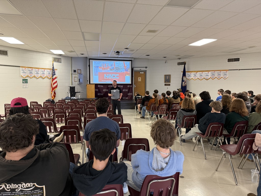 A man talks with students in an auditorium.