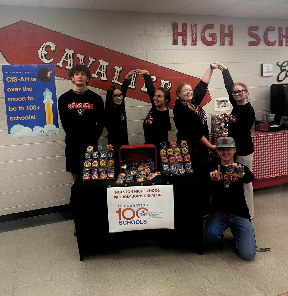 Students form the number 100 and pose next to a table of Moon Pies.