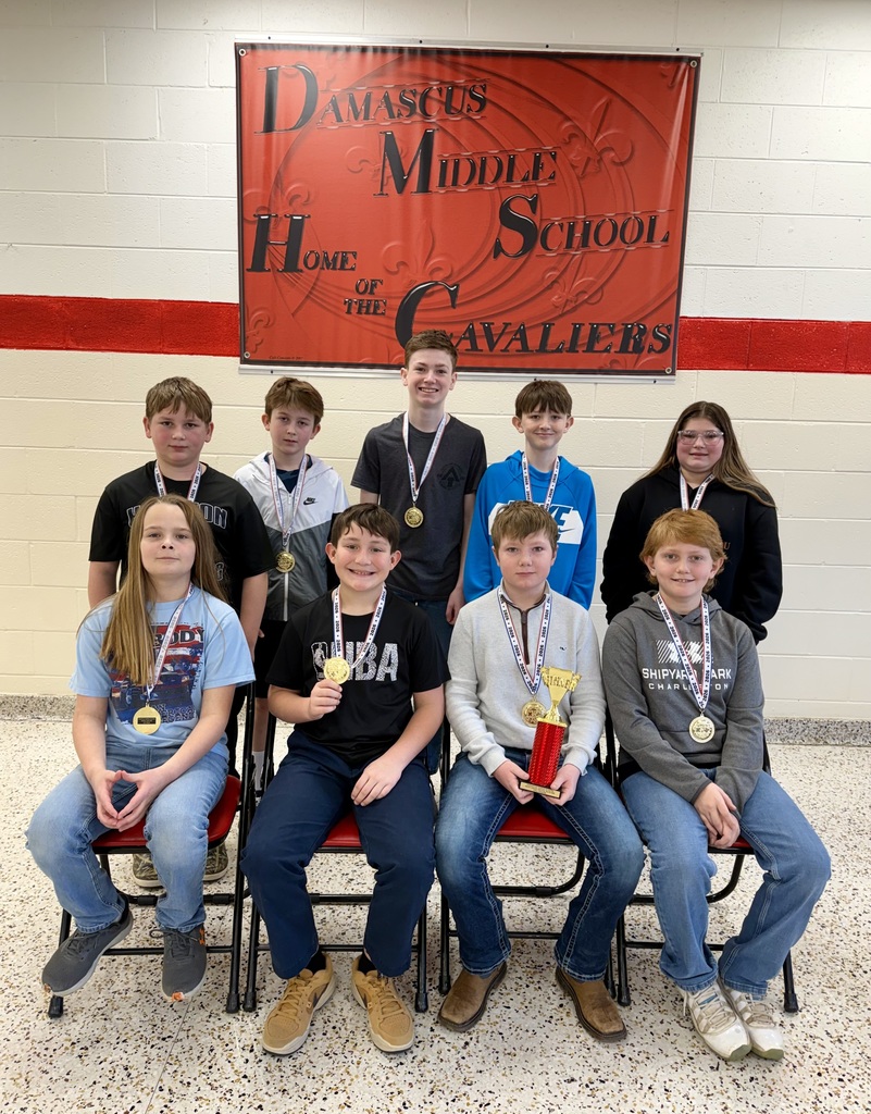A group of students pose in a cafeteria.