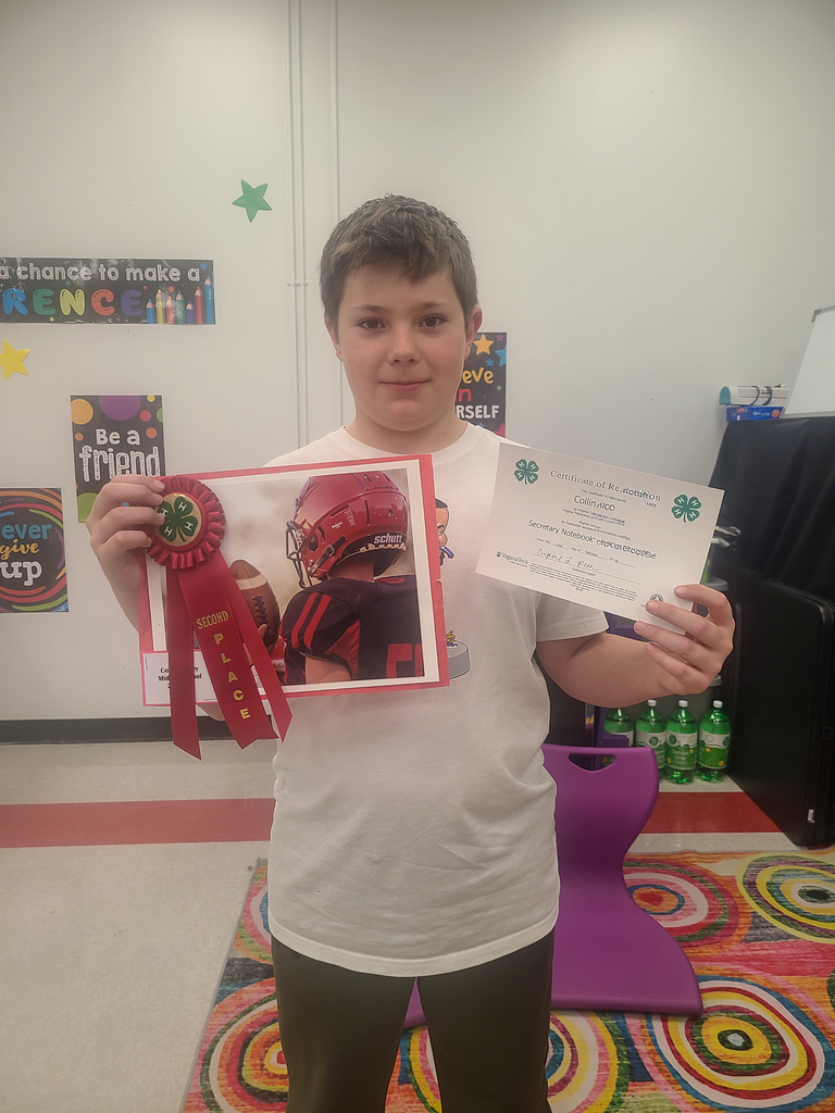 A student holds a photograph with a red ribbon on it and a certificate.