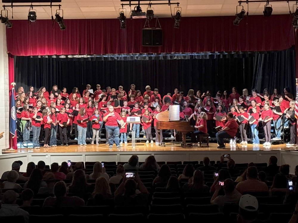 A group of students pose on a stage.