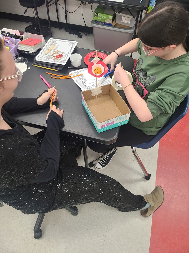 Students build a basketball hoop.