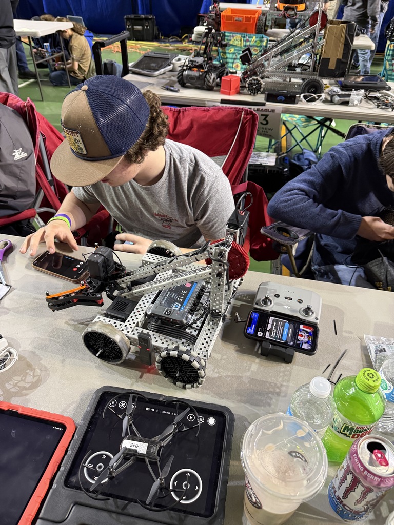 A student works on a robot at a Robotics competition.
