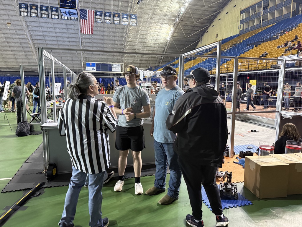 Students talk to a judge at a Robotics and Drone competition.