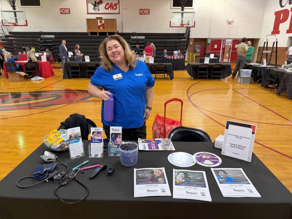 A woman poses with a table of career materials.
