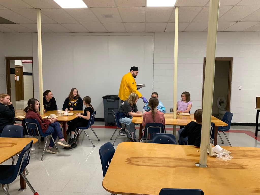 A chef talks to a group of students in a classroom.
