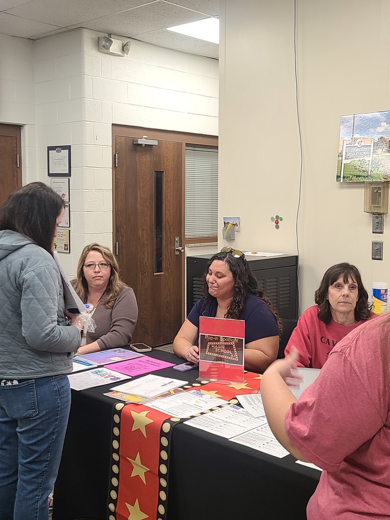 A teacher talks with other teachers in a PD session.