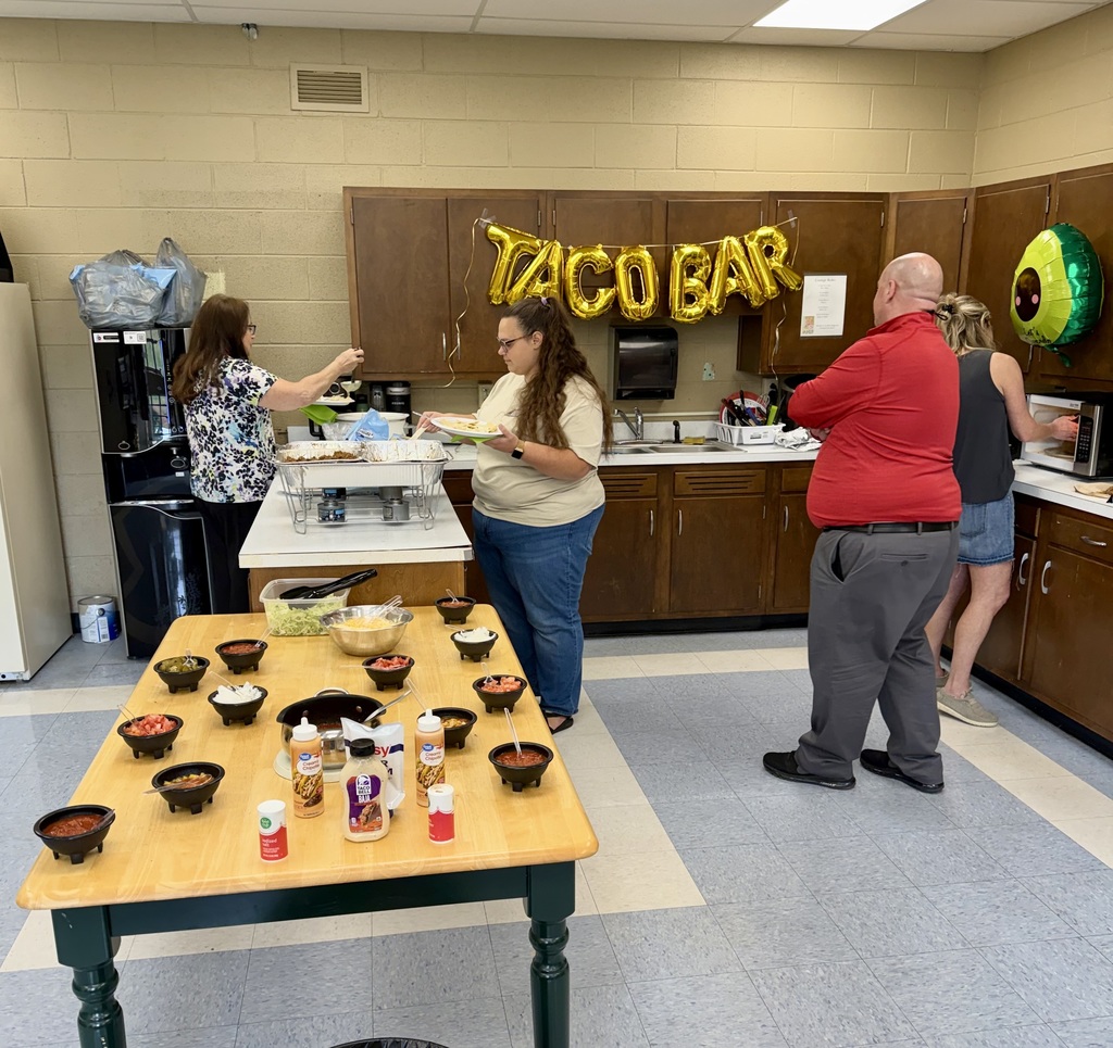 Teachers enjoy a taco bar with decorations.