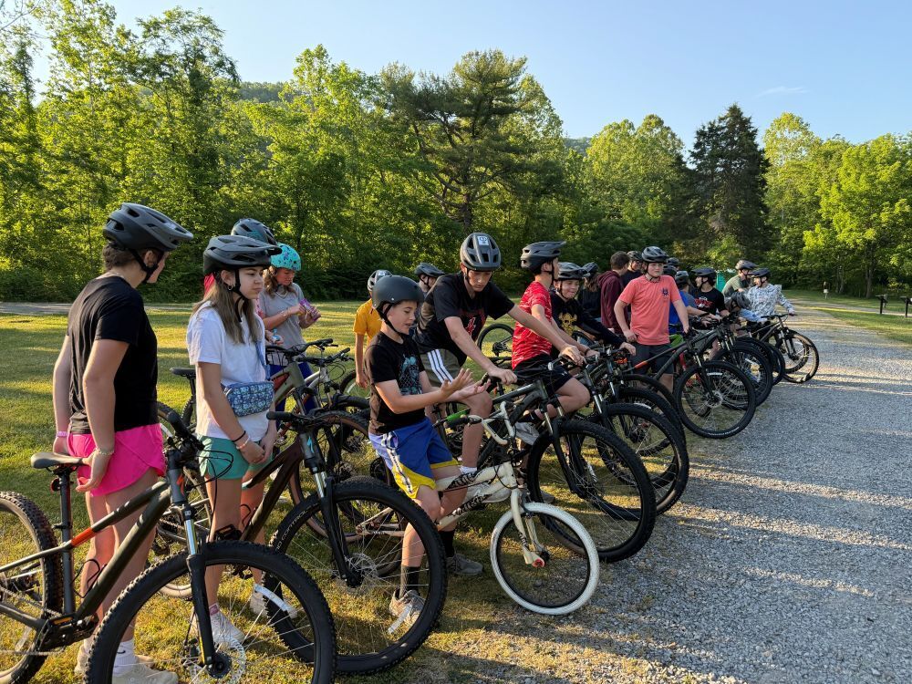 A group of people sit on bikes.