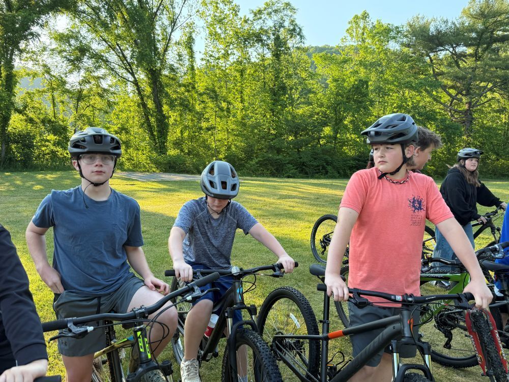 A group of people sit on bikes.