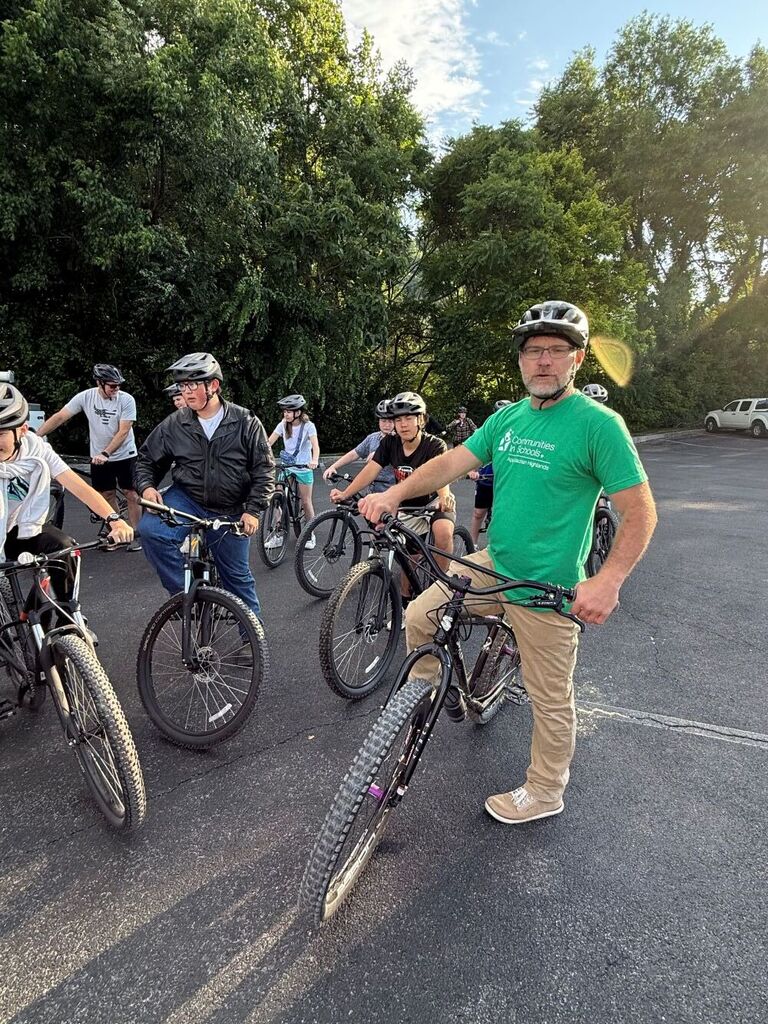 A group of people sit on bikes.
