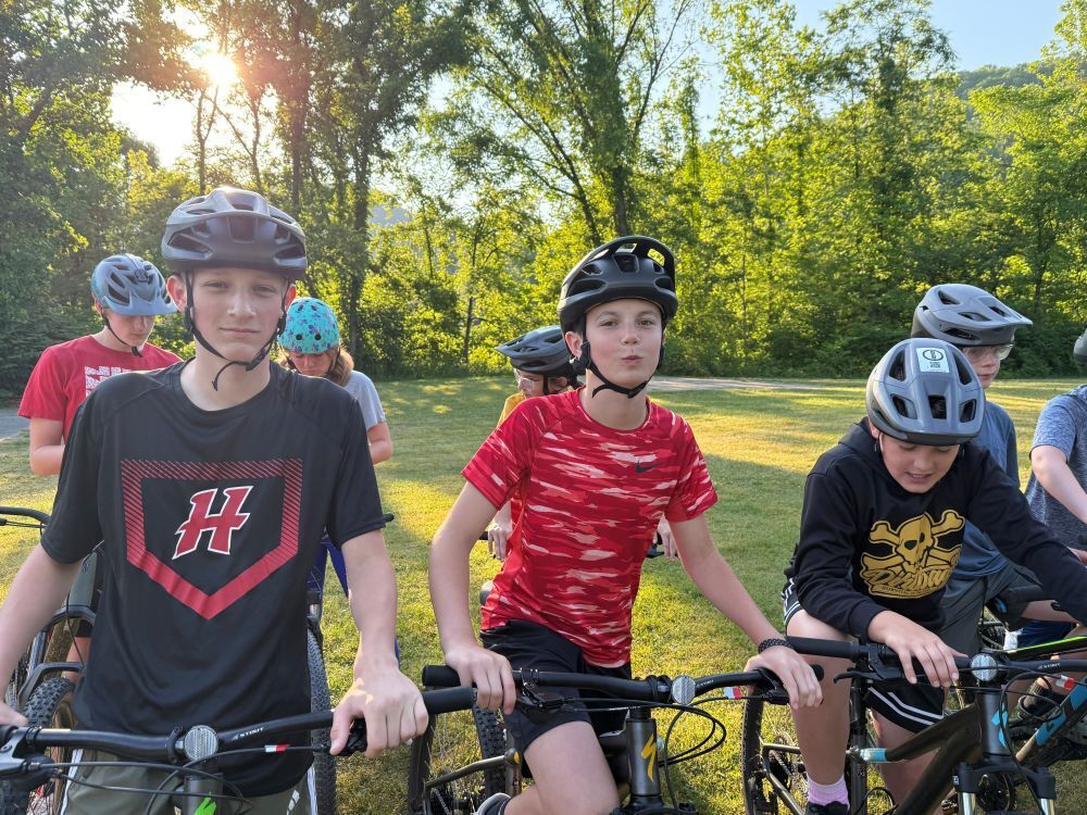 A group of people sit on bikes.
