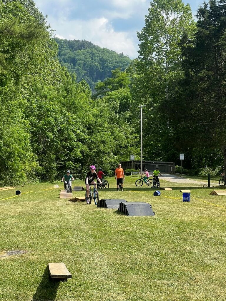 People rides bikes over ramps.
