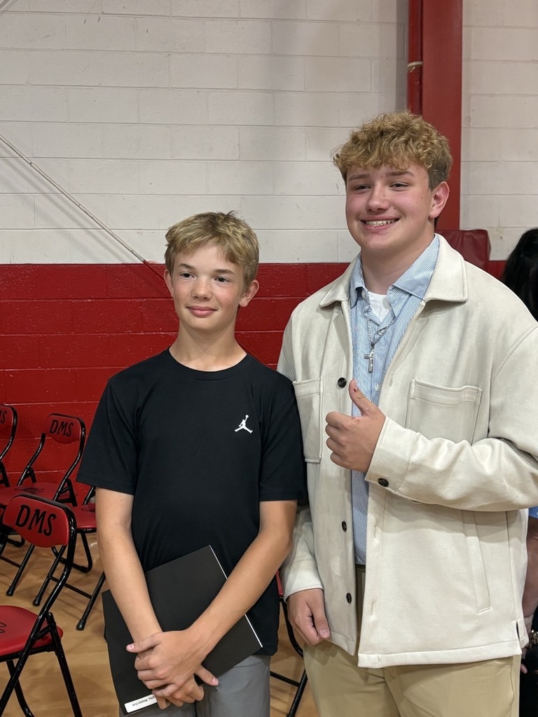 Two students pose in a gym.