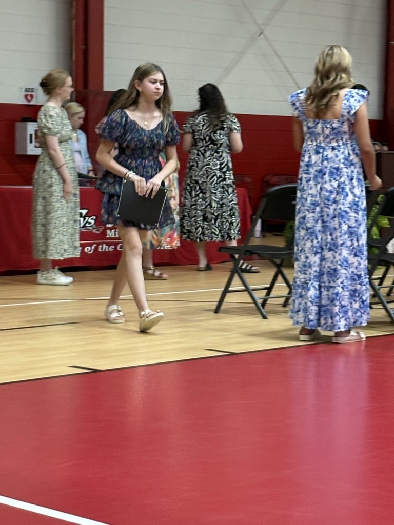 A student walks with her certificate of completion.