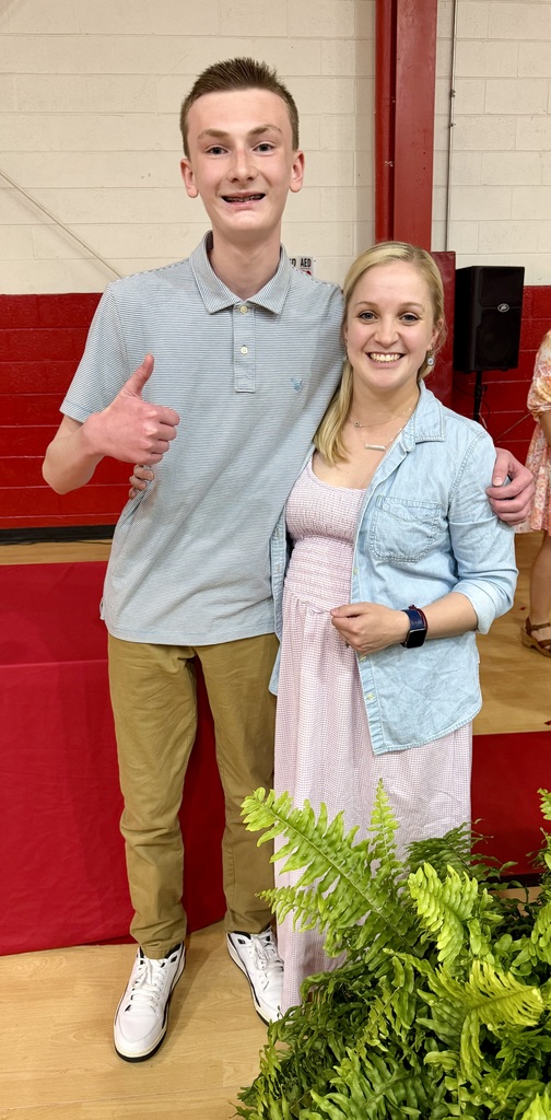 A student poses with a teacher.