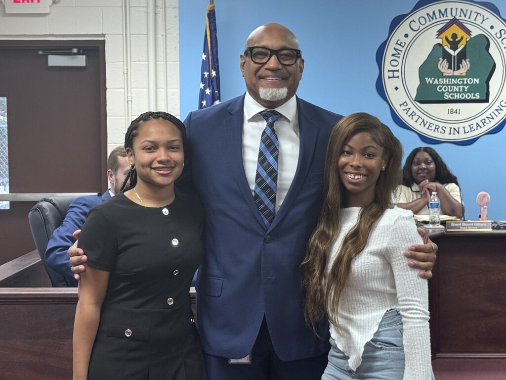 students with superintendent of schools posing for a photo