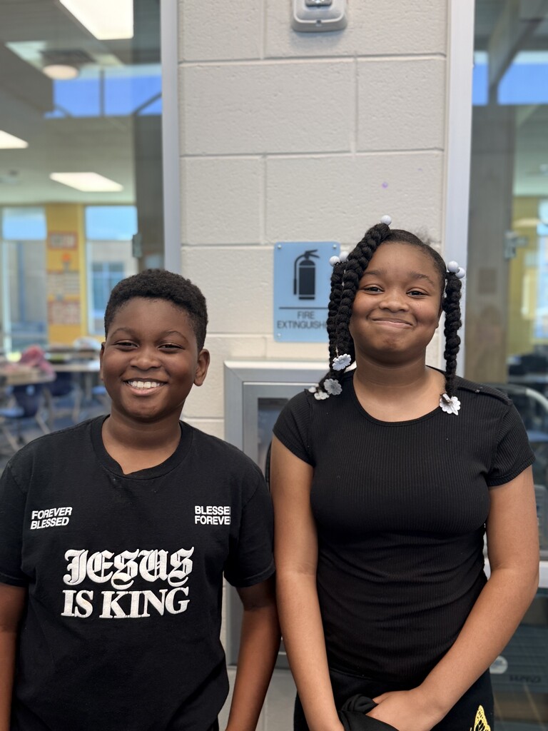 2 students wearing black shirts with big smiles.