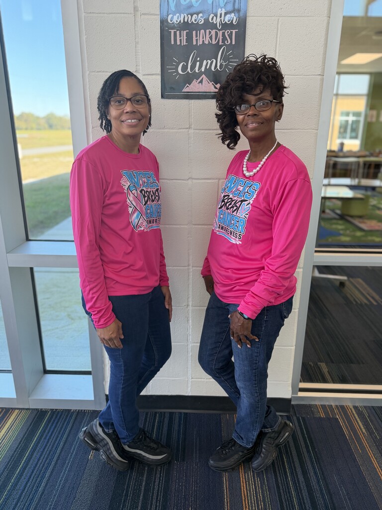 Both Ms. Gallop's in pink shirts and jeans.
