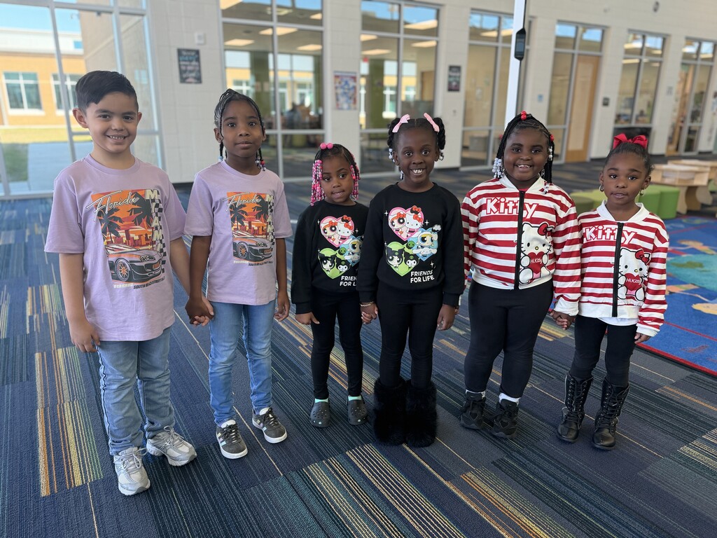 3 sets of twins. The first pair is wearing purple shirts and jeans, the second set is wearing black shirts and pants, the third set is wearing red and white striped jackets and black pants.