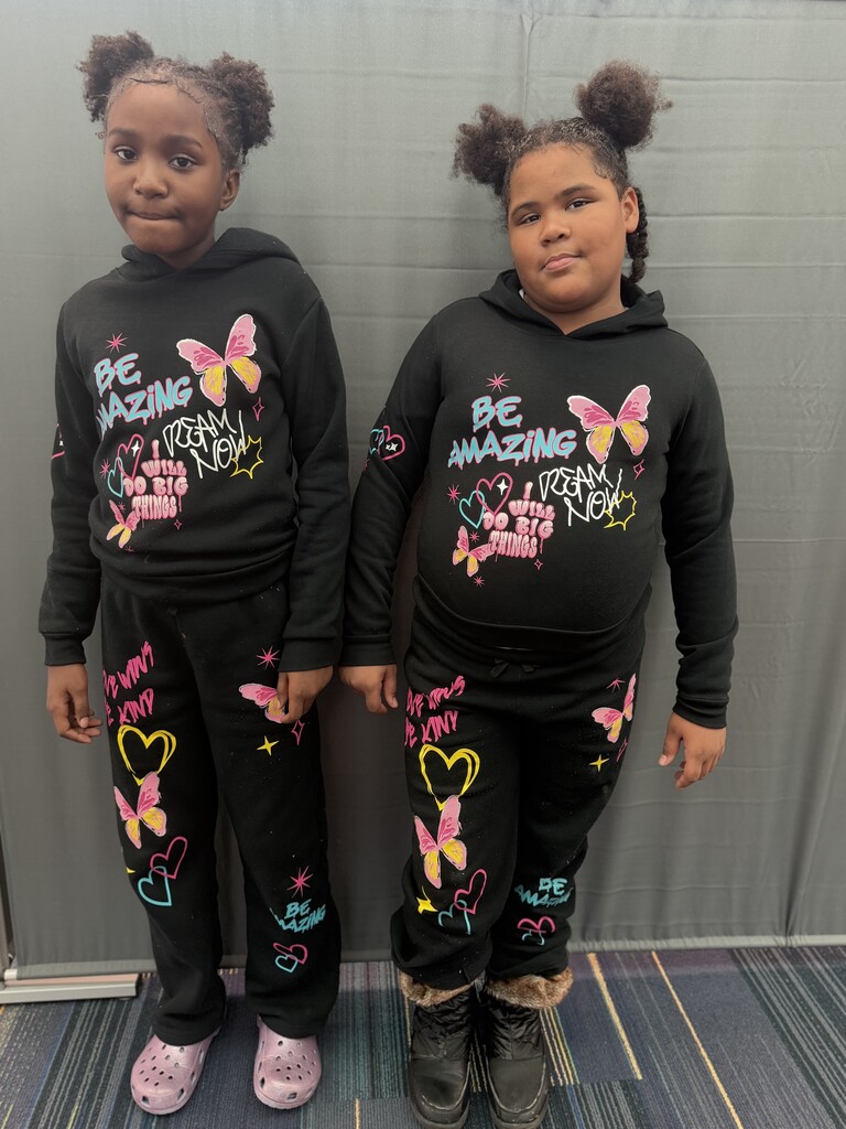 2 girls twinning with black sweatshirts and sweatpants.