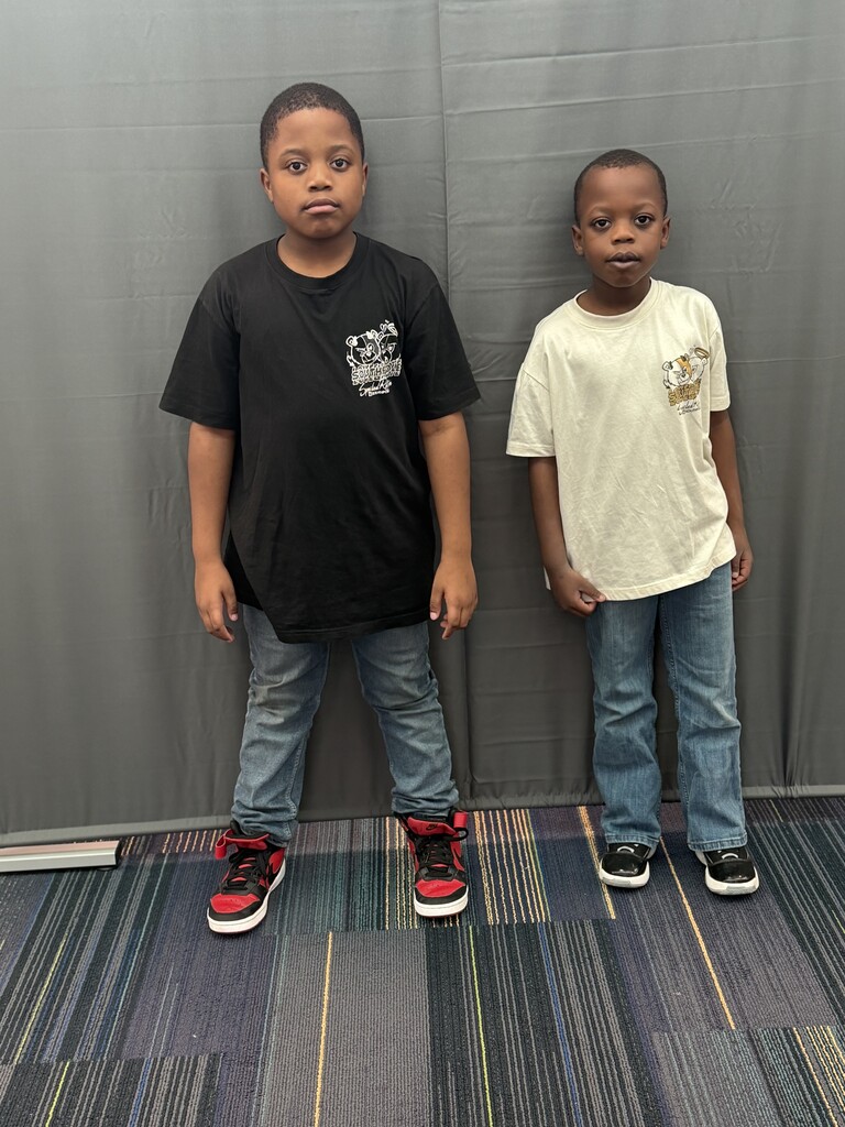 1 student wearing a black shirt and jeans and another student wearing a tan shirt with jeans.