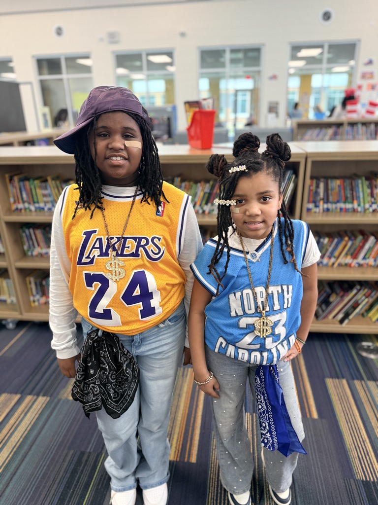 2 students wearing basketball jerseys and jeans.