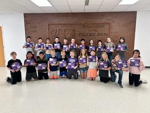 Elementary students showing off their new book.